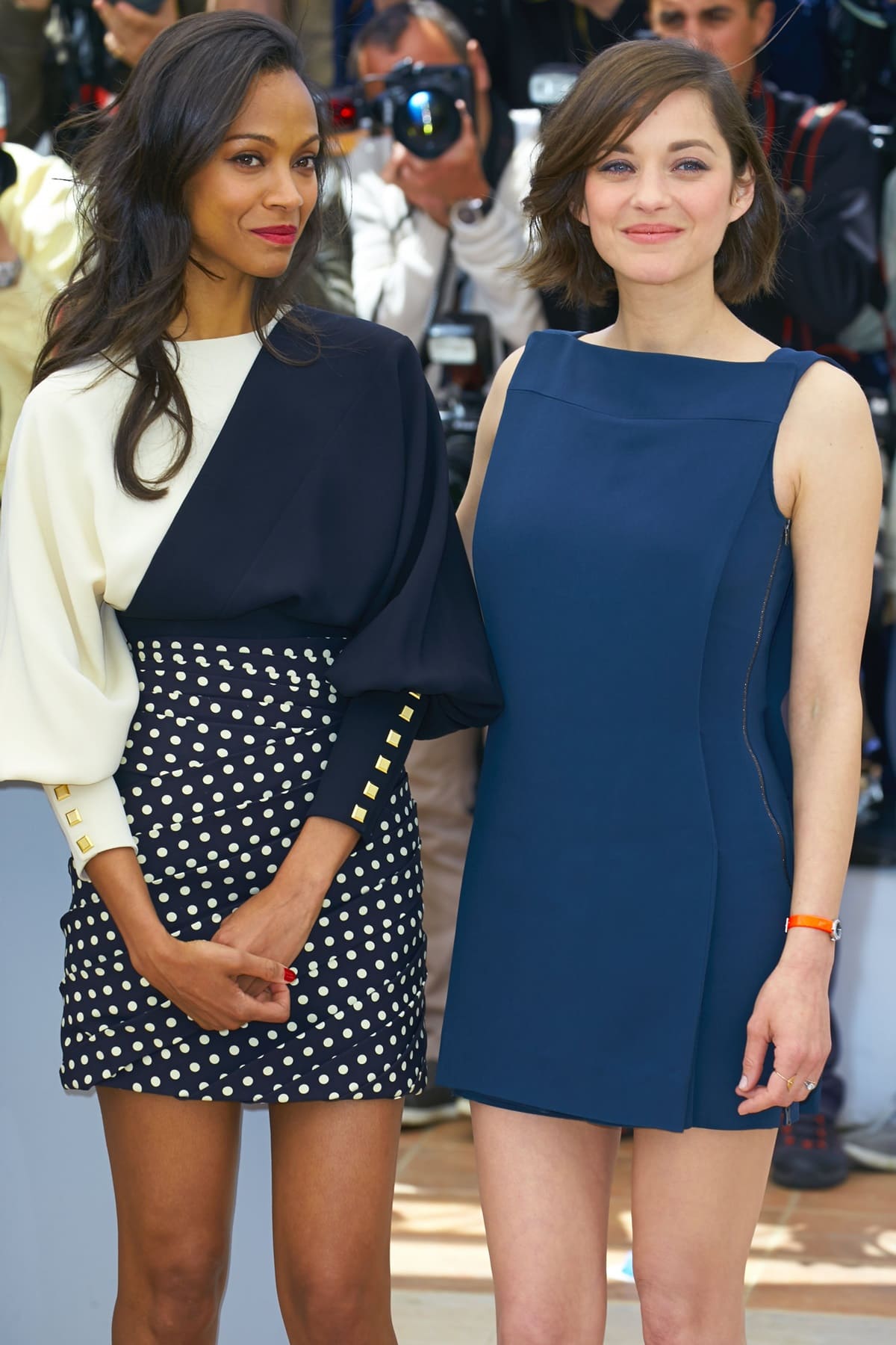 Zoe Saldana stuns in a chic polka-dot mini skirt with a dramatic two-tone blouse, while Marion Cotillard exudes elegance in a sleek navy asymmetrical dress