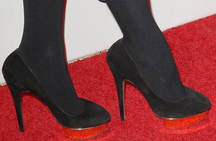 Paris Hilton steps out in sleek black platform pumps with wooden accents, adding height and sophistication to her red carpet look