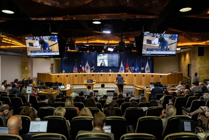 People are shown seated in front of council members in Ausitn City Hall