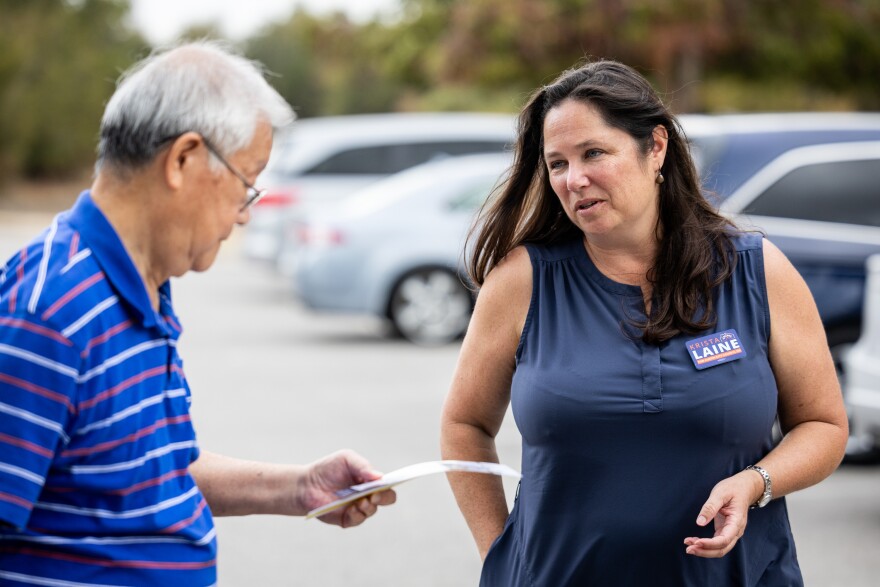 A woman and a man are shown speaking outside a polling station.