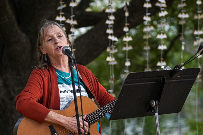 Emmy Sawvel, an activist and musician, perfroms a song written by a deceased homeless friend at a memorial service at Auditorium Shores on Sunday, Nov. 17, 2024 in Austin. Advocates and members of the homeless community gathered to honor the more than 200 homeless people that died between September of 2023 and November of 2024.