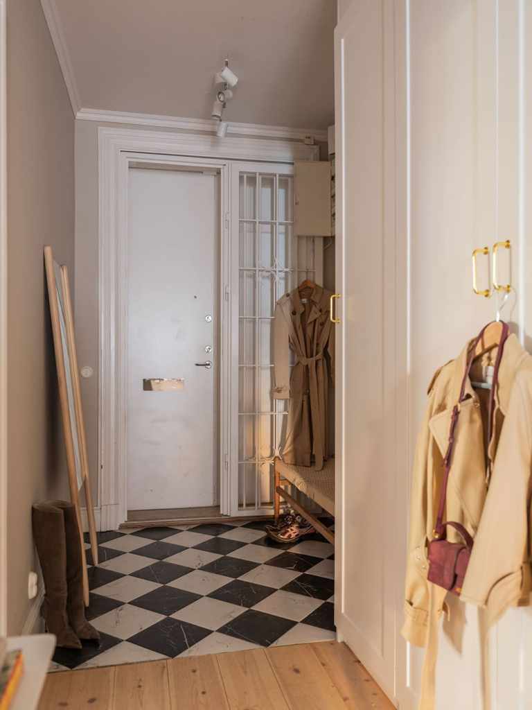 A hallway with a white wardrobe and marble flooring