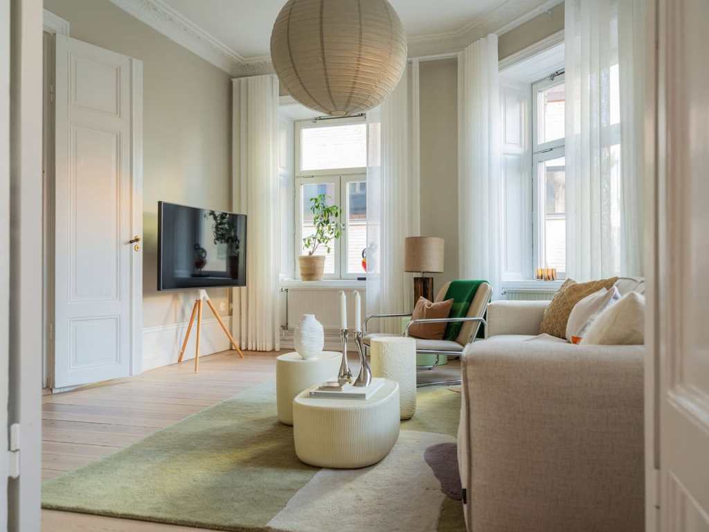 A beige living room with a white coach and green details