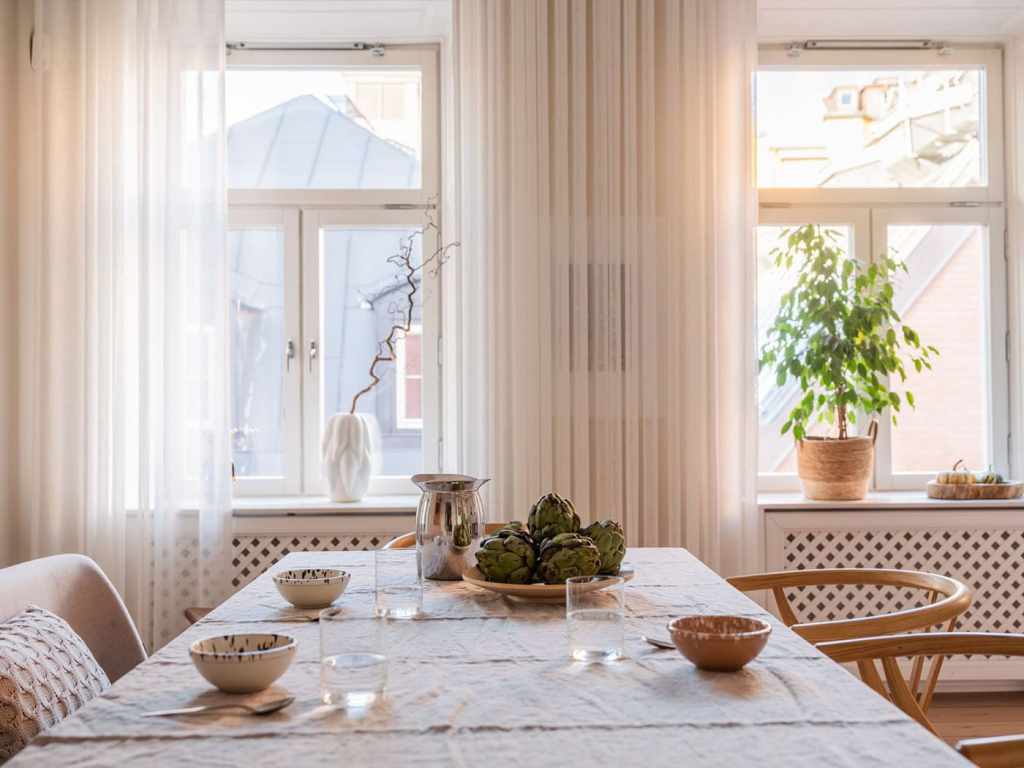 A white shaker kitchen with a spacious dining area in front of the window