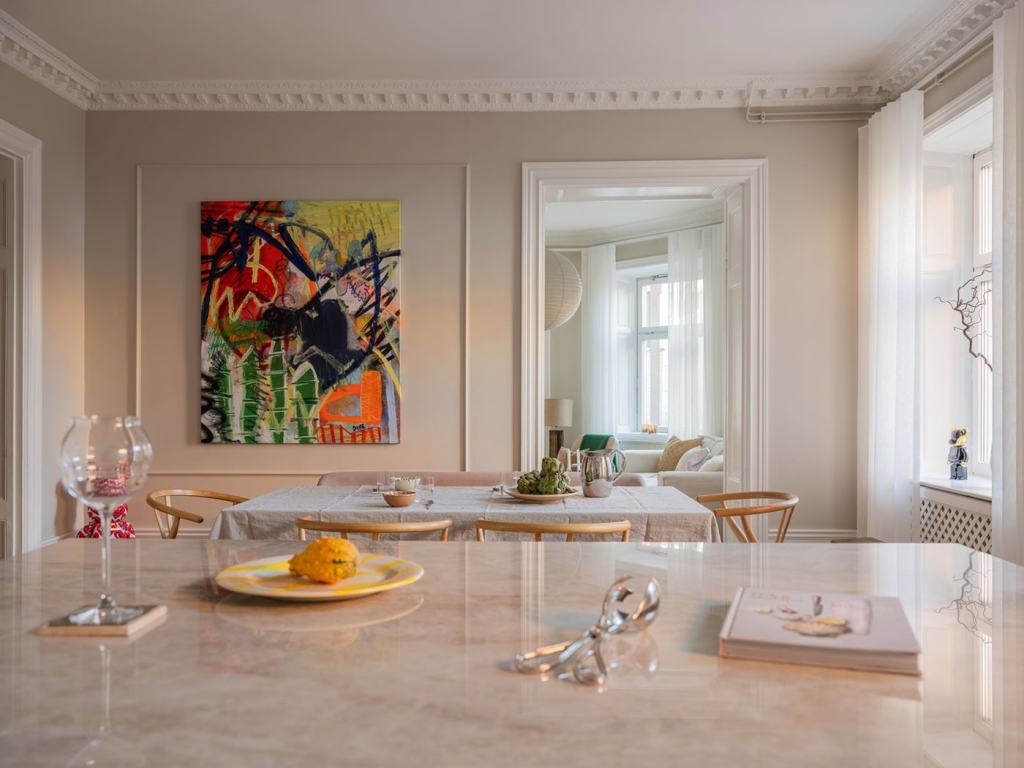 A white shaker kitchen with a spacious dining area in front of the window