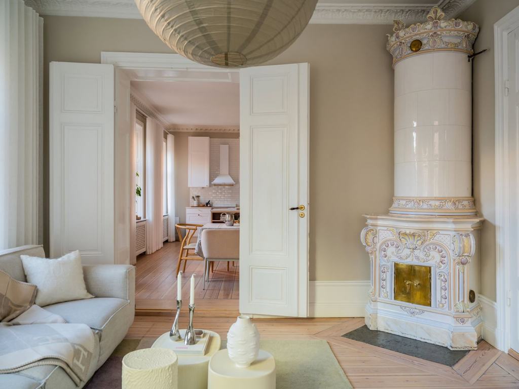 A beige living room with a white coach and green details