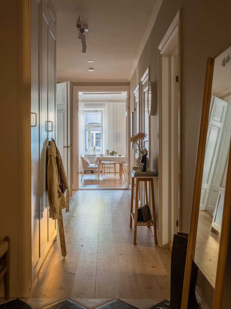 A hallway with a white wardrobe and marble flooring