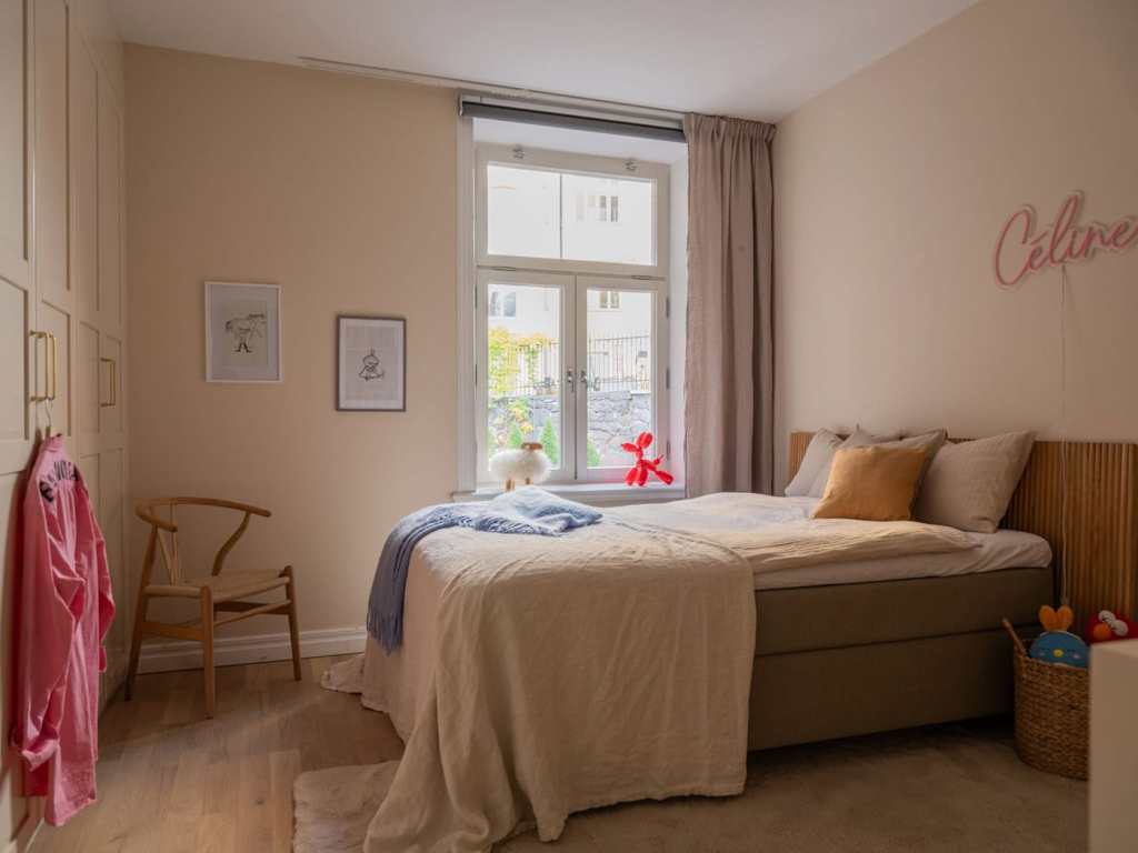 A warm beige kids room with pink details