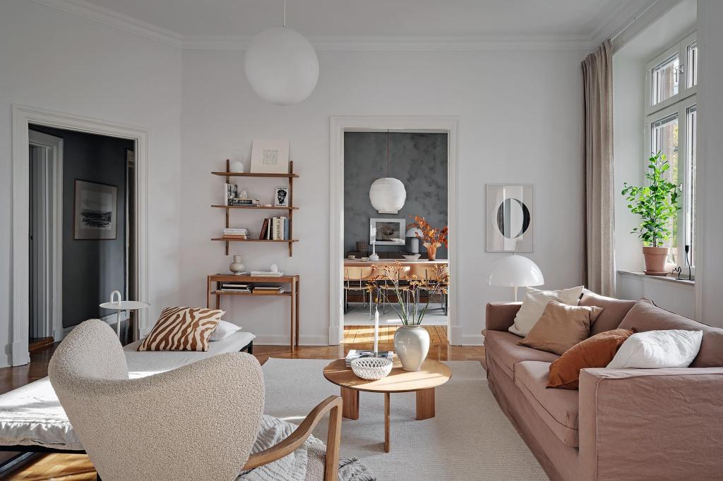 A living room with white walls and a natural color palette, brown sofa