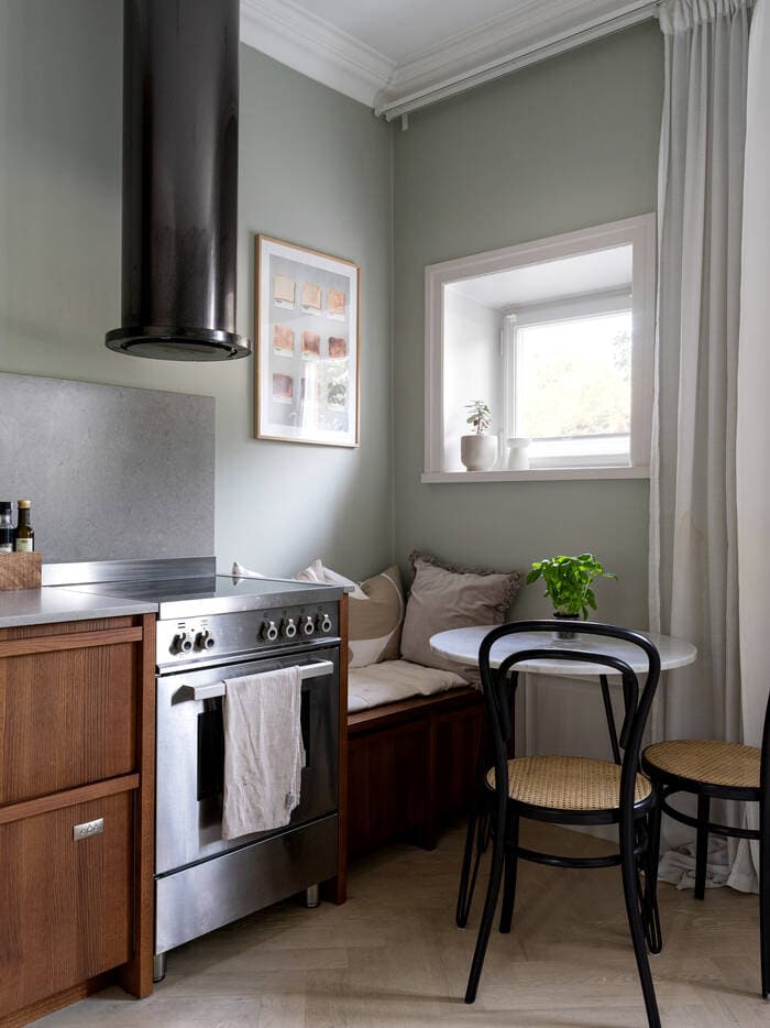 A small studio apartment with a walnut kitchen including a breakfast nook in front of the window