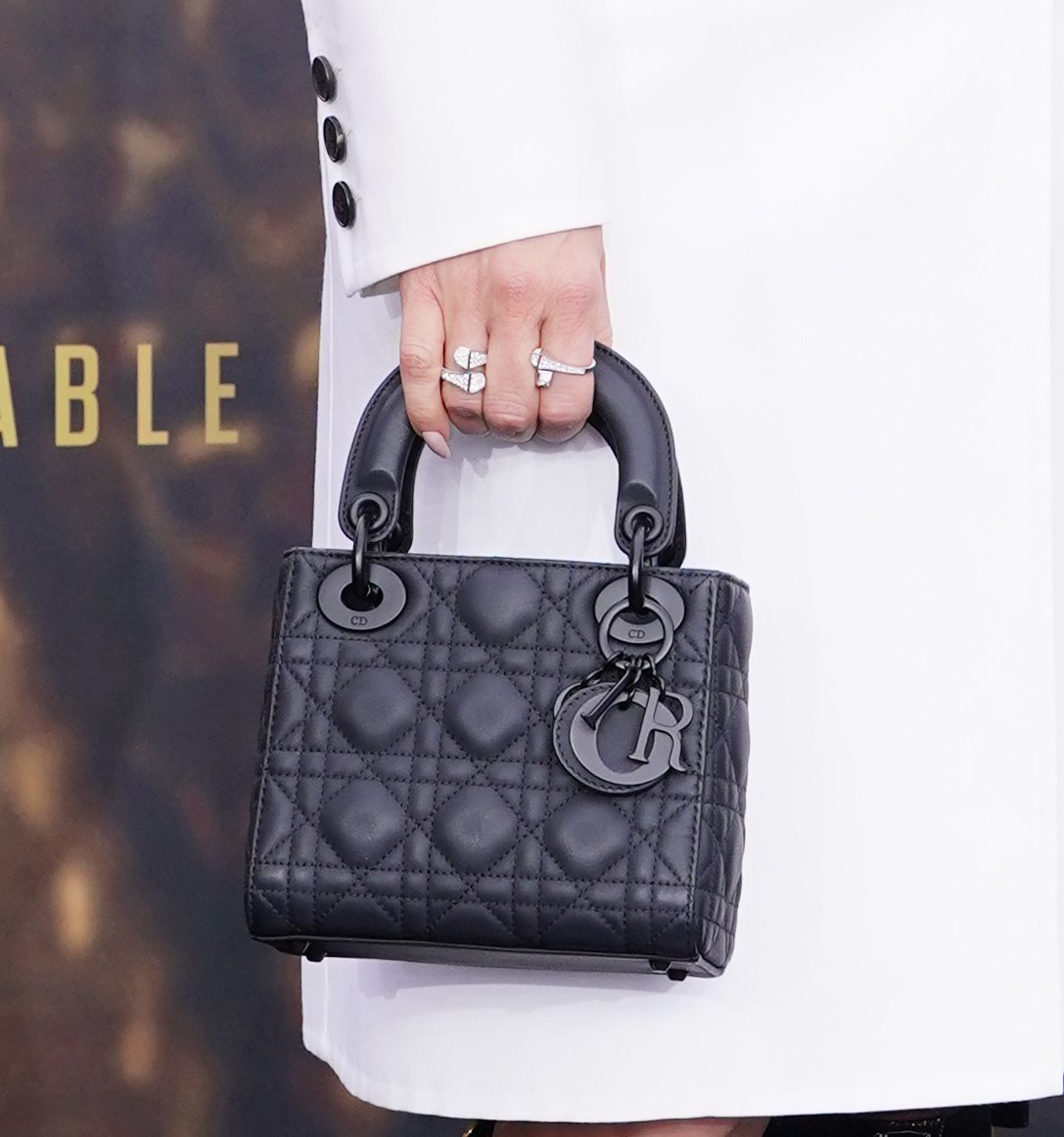 Jennifer Lopez carries a black Christian Dior Lady Dior bag—a staple in Princess Diana's 1990s ensembles