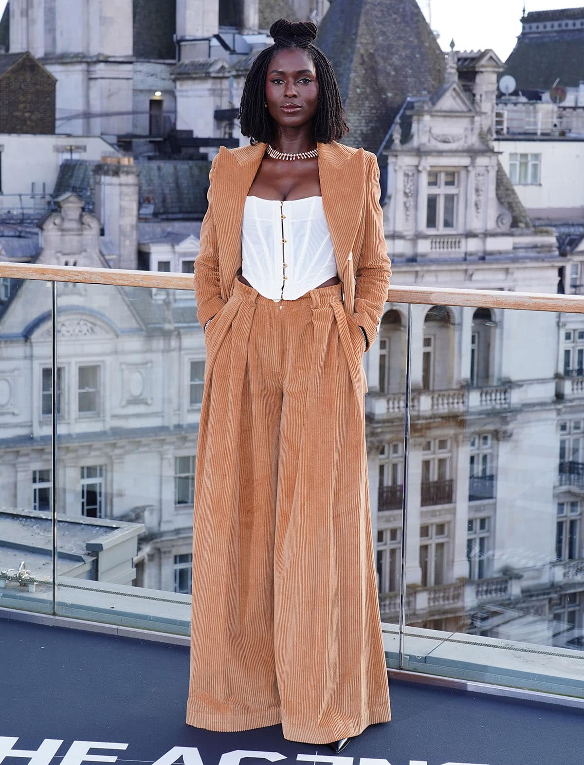 Jodie Turner-Smith embraces the 1970s in a tan corduroy S.S. Daley suit, with a white corset top for a contemporary, feminine touch