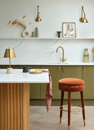 Olive green kitchen with white marble walls with wall lights and table lamp