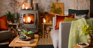 Rustic living room with an open stone fireplace with a black log burner to support a guide on what you need to know before buying a log burner