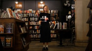 A young woman stands in a book store.