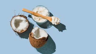 Halves of coconut and coconut in glass jar