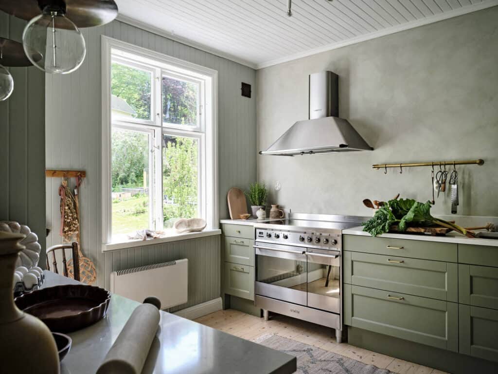 A sage green kitchen with a mix of limewash and normal paint on the walls