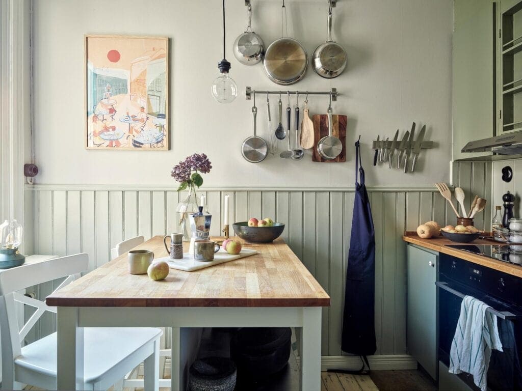 An older kitchen with sage green walls and wainscotting