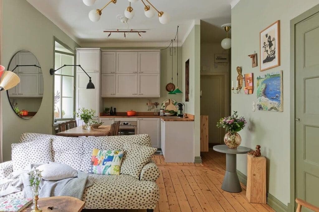 A living kitchen with sage green walls and gray kitchen cabinets