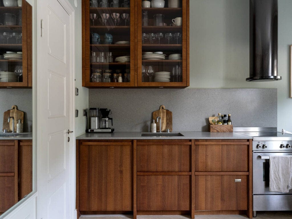 A dark wood kitchen with clary sage green walls