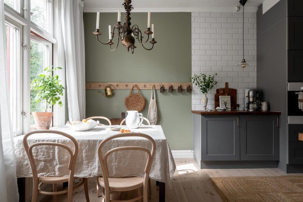 A dark sage green wall color in a kitchen with dark gray cabinets