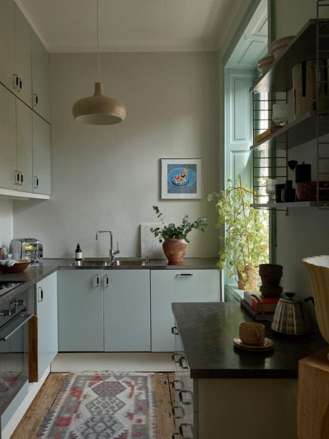 Sage green paint in different shades on both the walls and cabinets of this kitchen