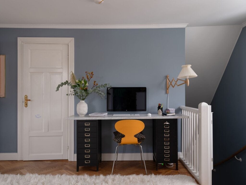 A Bold, Standard-Sized Desk With a Bright Chair to Fill the Unused Space at the Top of the Stairs