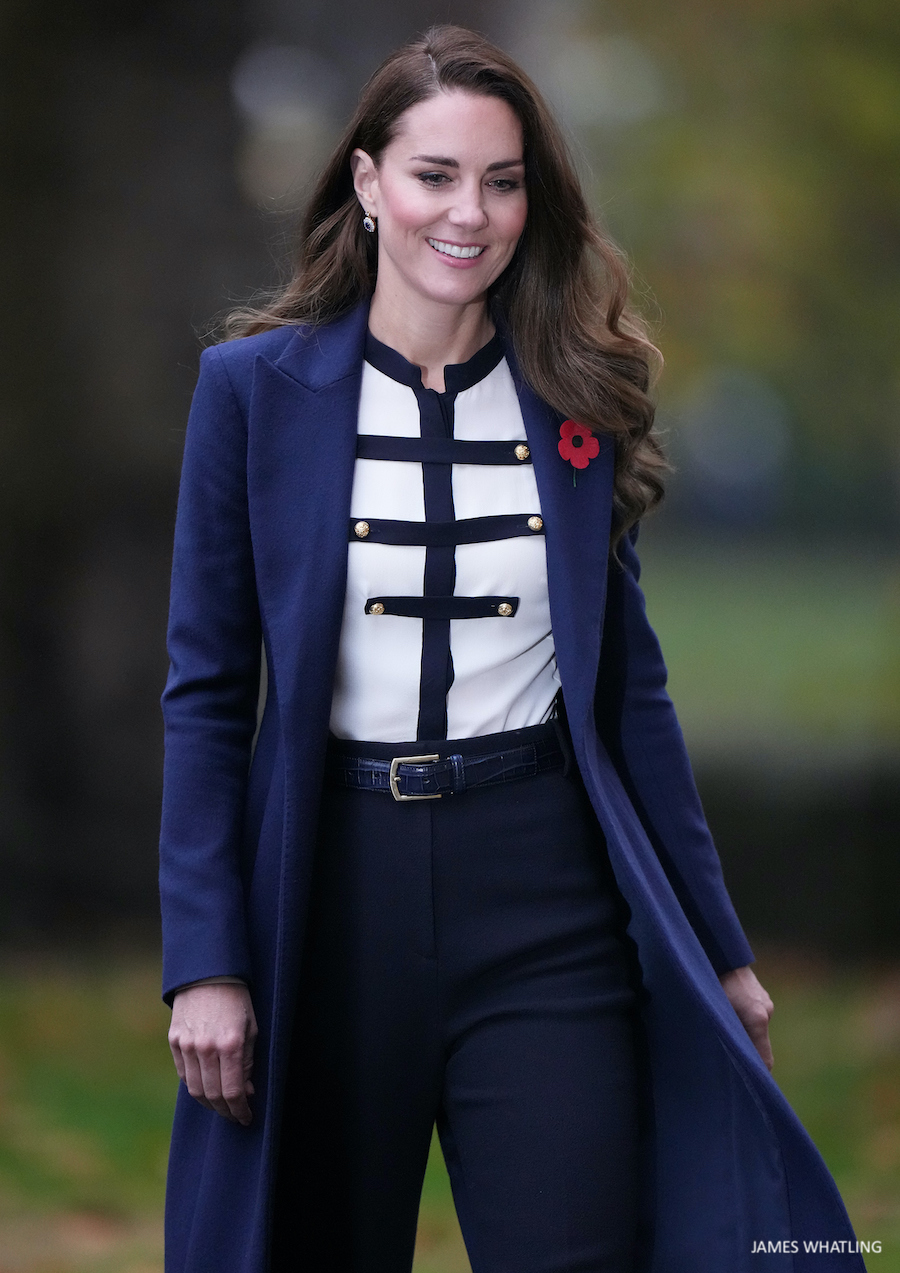 Kate Middleton smiling, wearing a white military-style blouse