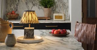 white and black marble kitchen counter with a lamp to show how to make a kitchen cosy