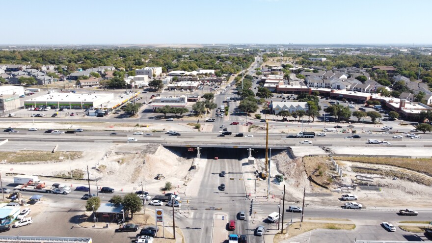 An aerial image of the I-35 bridge over Rundberg Lane. Construction has already begun with the southbound bridge demolished. Piles of dirt and construction activity is shown next to the bridge. 