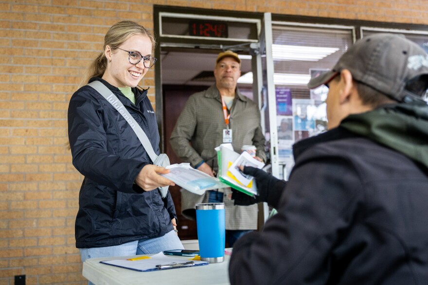 Hannah Smith, an assessor with Sunrise Homeless Navigation Center, hands a mask to a client.