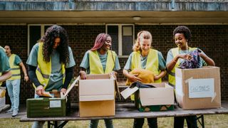 Four women volunteering and boxing up items