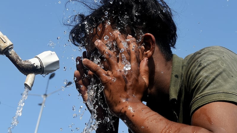 A worker splashes water on his face in an effort to keep cool as temperatures rose in Mumbai in April.