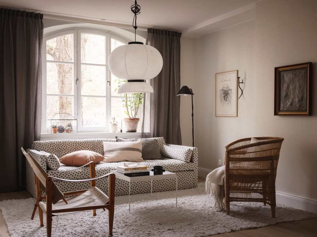 A living room with a polka-dot sofa and natural armchairs