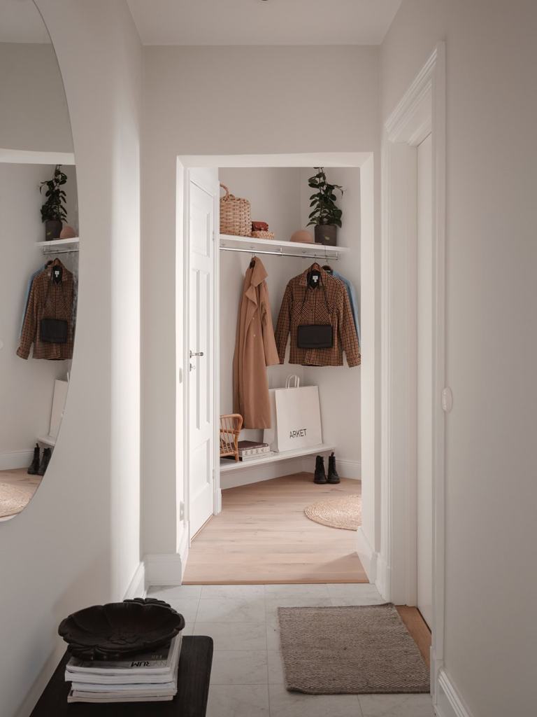 A white hallway with a big round mirror