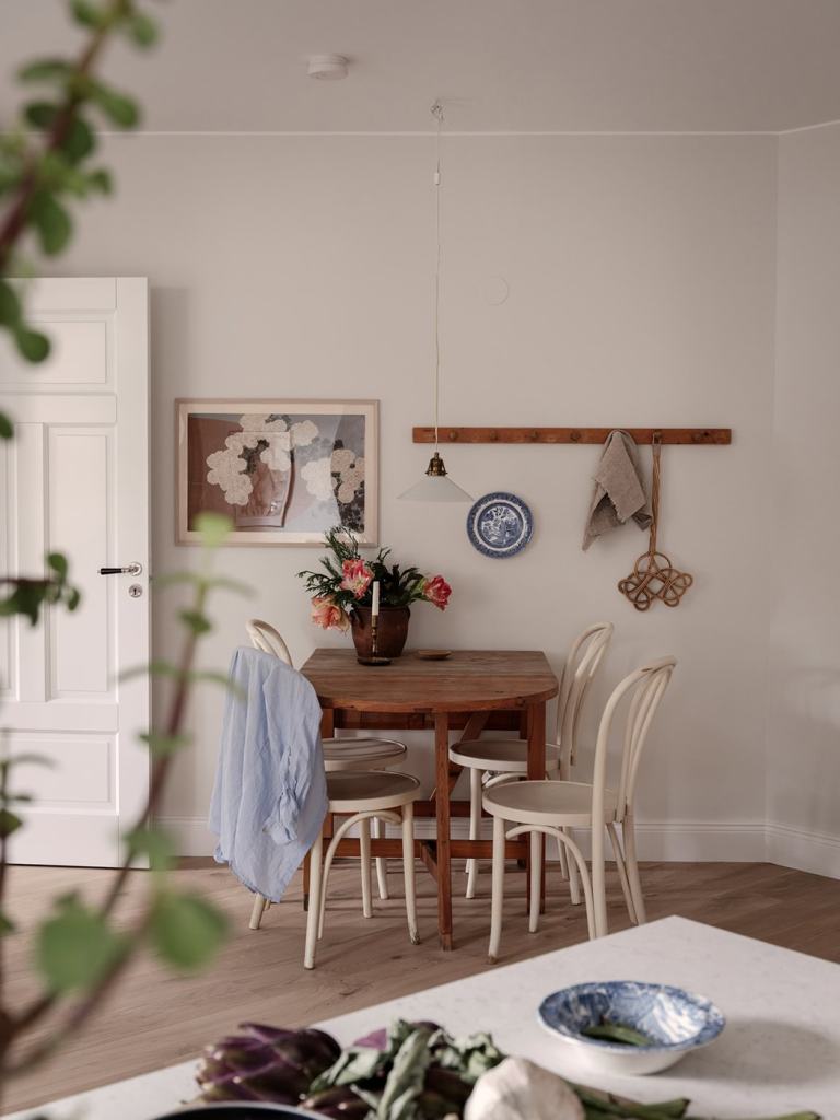 A dining area with a vintage dining table and antique white bentwood chairs