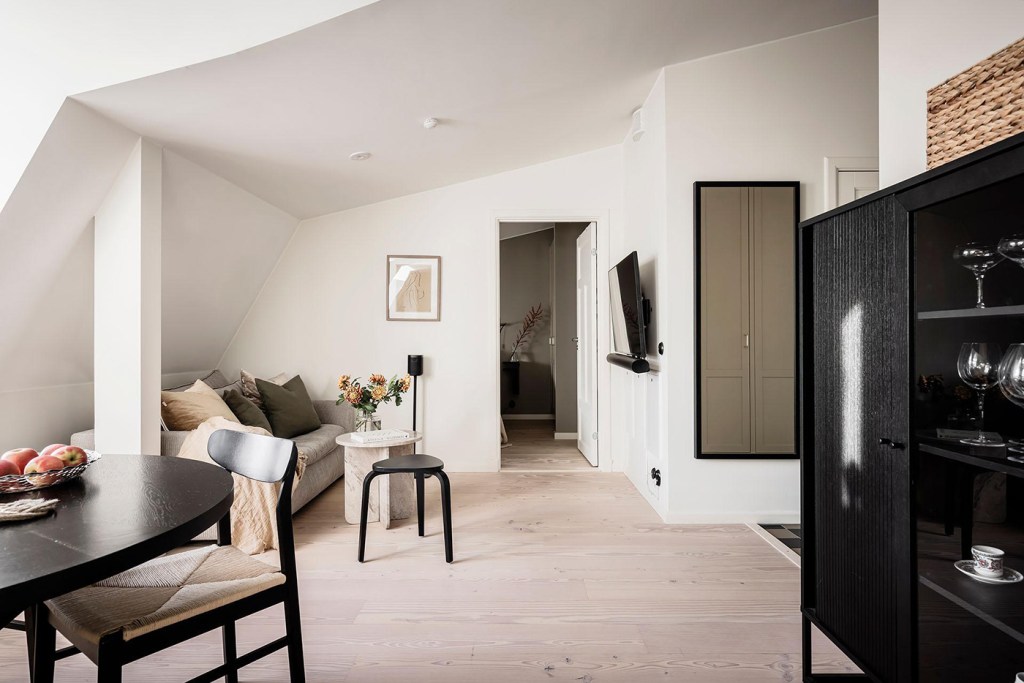 An attic living room with the sofa underneath the sloped roof