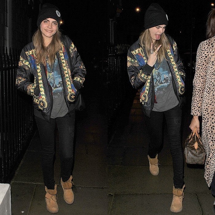 Cara Delevingne channels streetwear cool with Timberland boots, a graphic tee, a bold patterned bomber jacket, and a cozy beanie for a laid-back night out