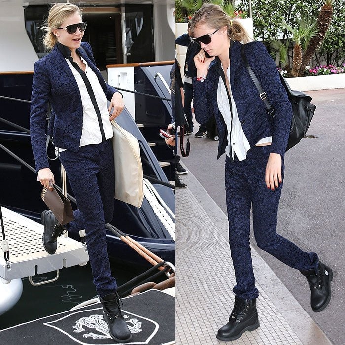 Cara Delevingne pairs rugged black Timberland boots with a navy lace suit and crisp white shirt, effortlessly blending feminine elegance with edgy style