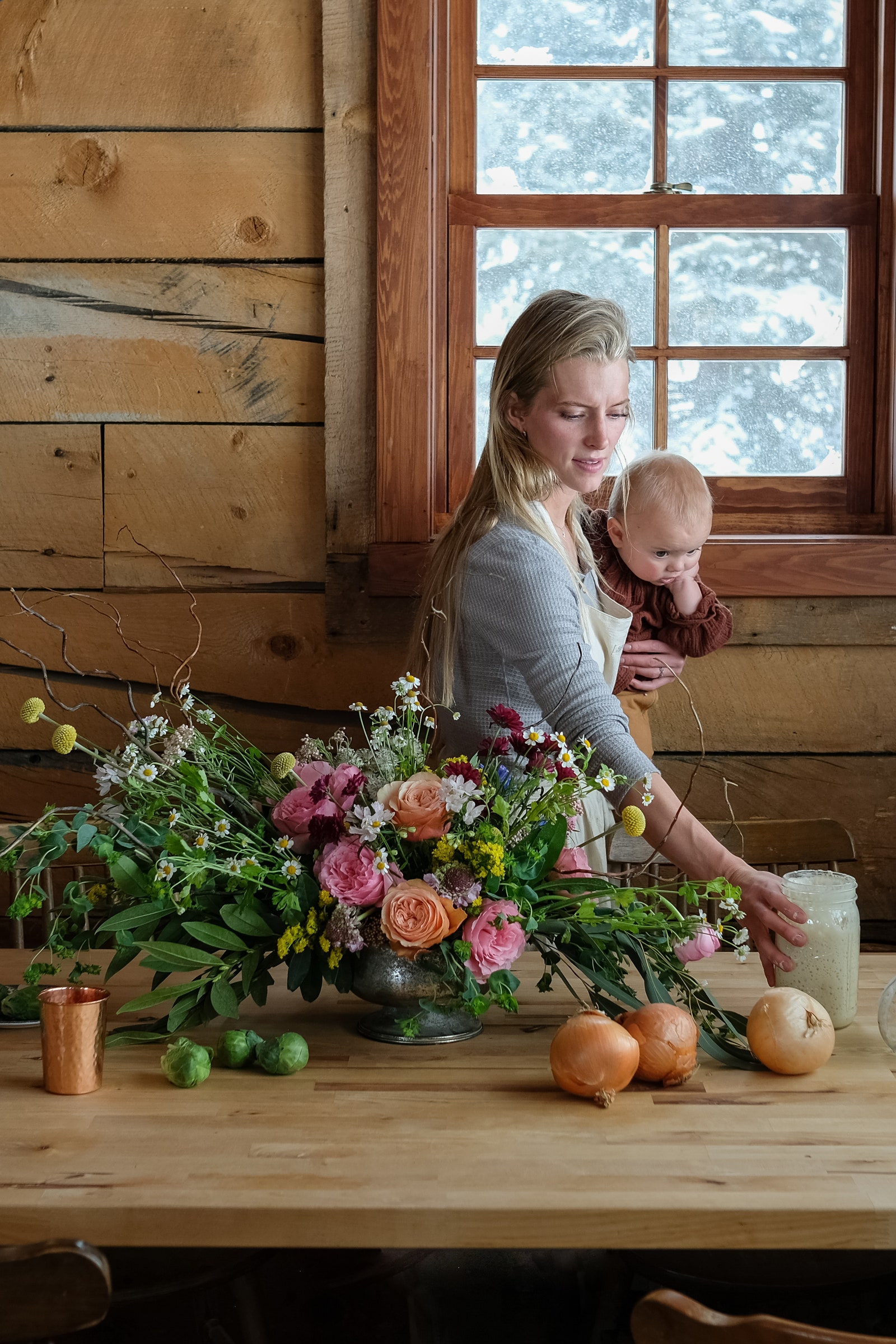 Image may contain Adult Person Flower Flower Arrangement Plant Flower Bouquet Furniture Table Potted Plant and Wood