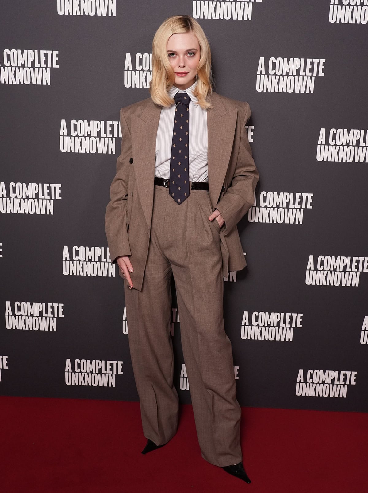 Elle Fanning borrows from the boys in a brown Saint Laurent Spring 2025 suit with a polka-dot necktie and a pinstripe shirt at the London photocall for A Complete Unknown at Curzon Mayfair