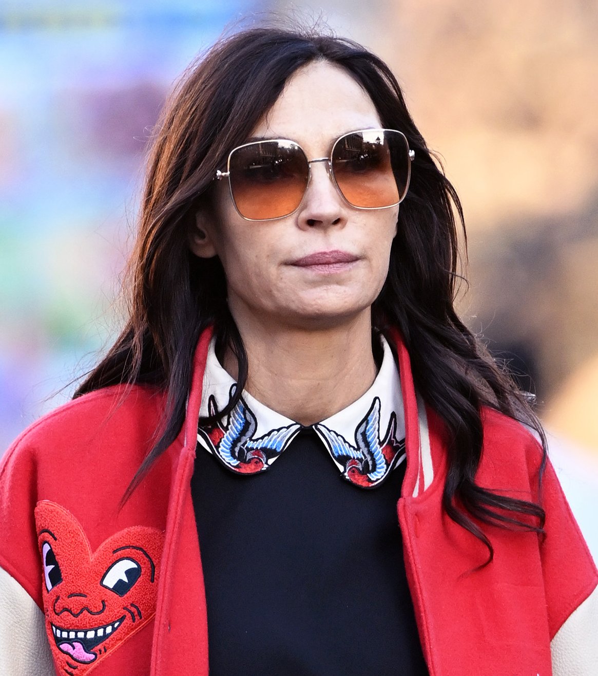 Famke Janssen completes her chic stroll ensemble with a Red Valentino tote bag and a pair of large, square-framed ombre sunglasses