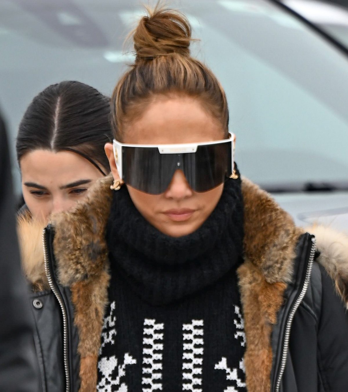 Jennifer Lopez wears her hair in a topknot and covers her eyes behind Versace's Medusa Icon Shield sunglasses