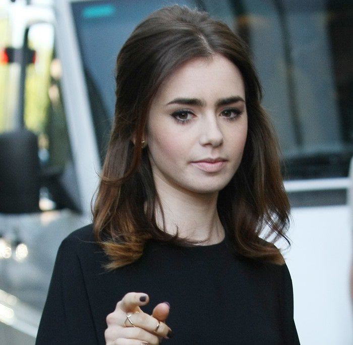 Lily Collins exudes effortless sophistication with her classic makeup and soft waves, perfectly complementing her poised black ensemble