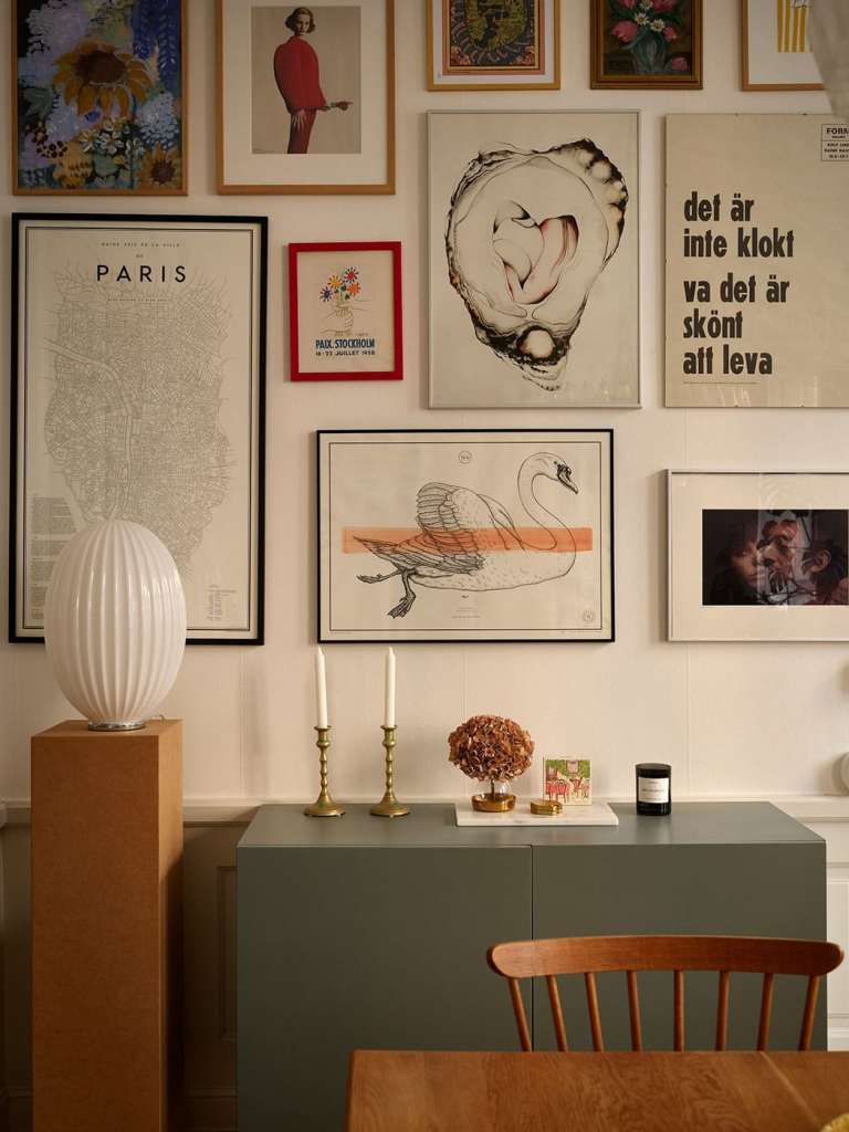 A dining room with a vintage dining table and an impressive gallery wall