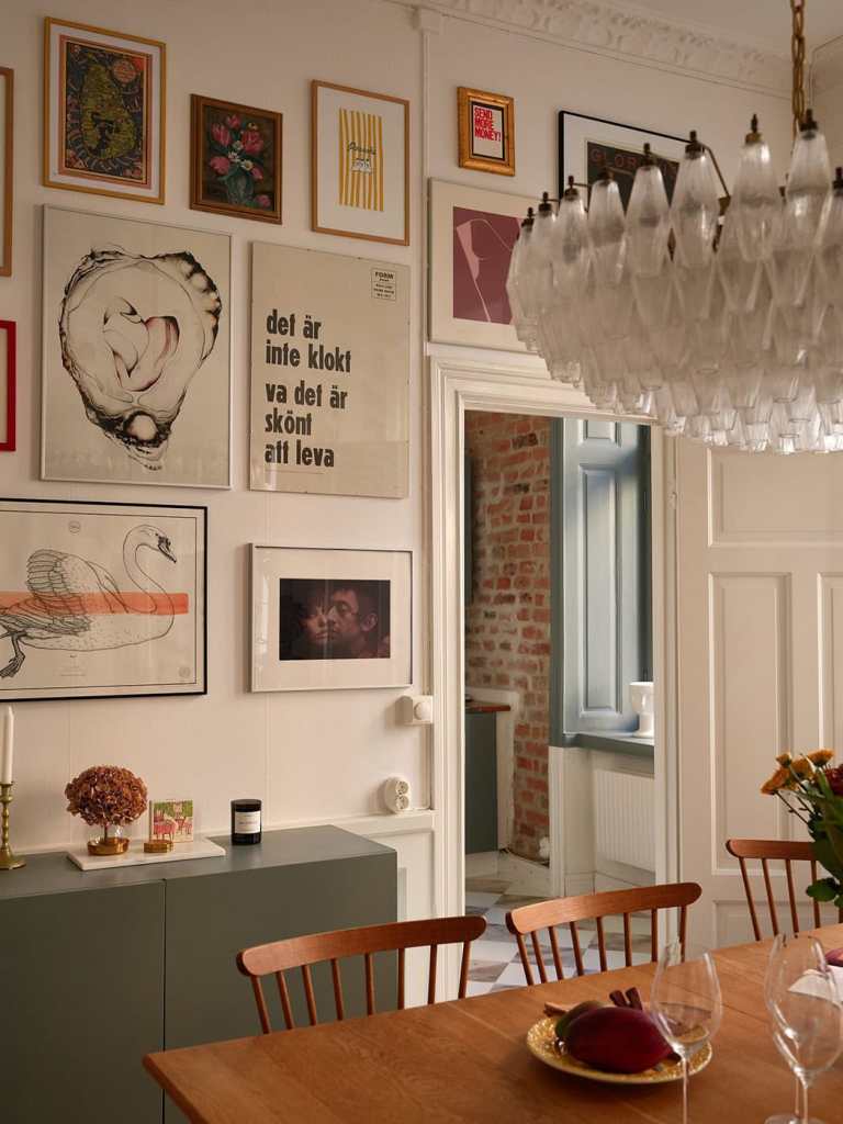 A dining room with a vintage dining table and an impressive gallery wall