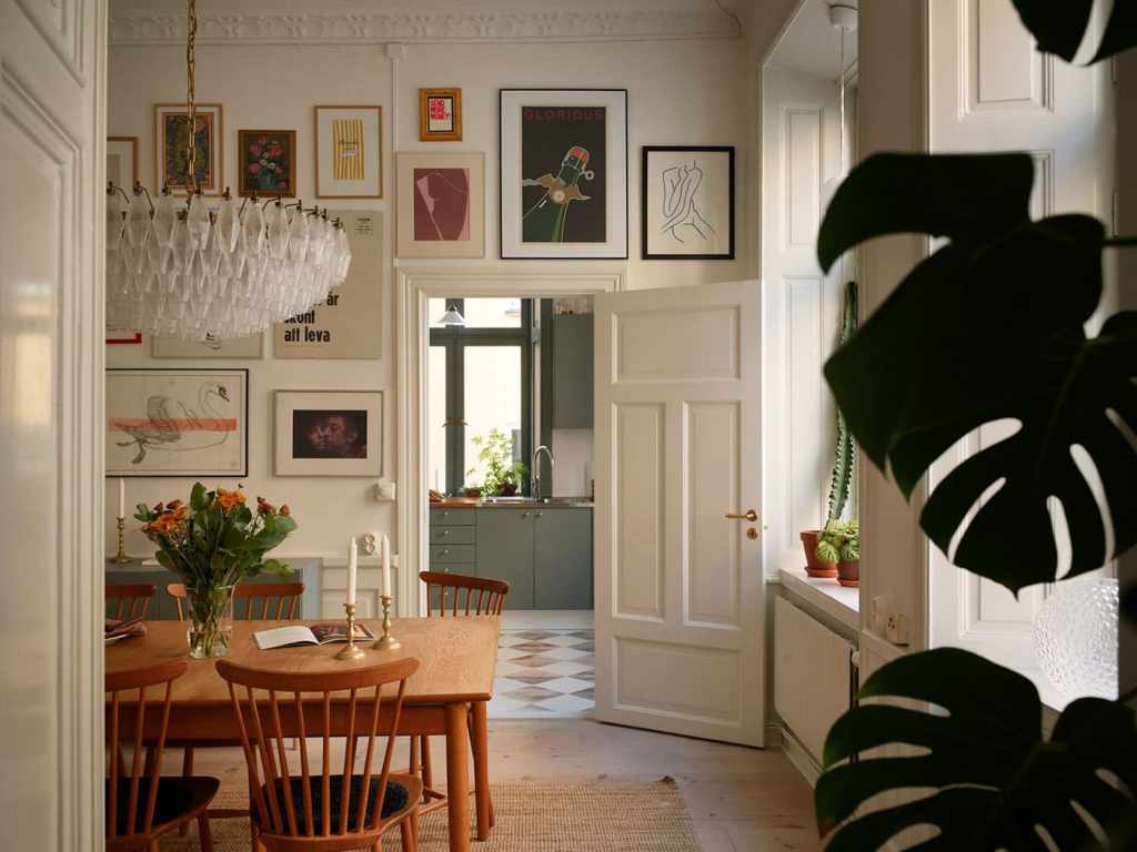 A dining room with a vintage dining table and an impressive gallery wall