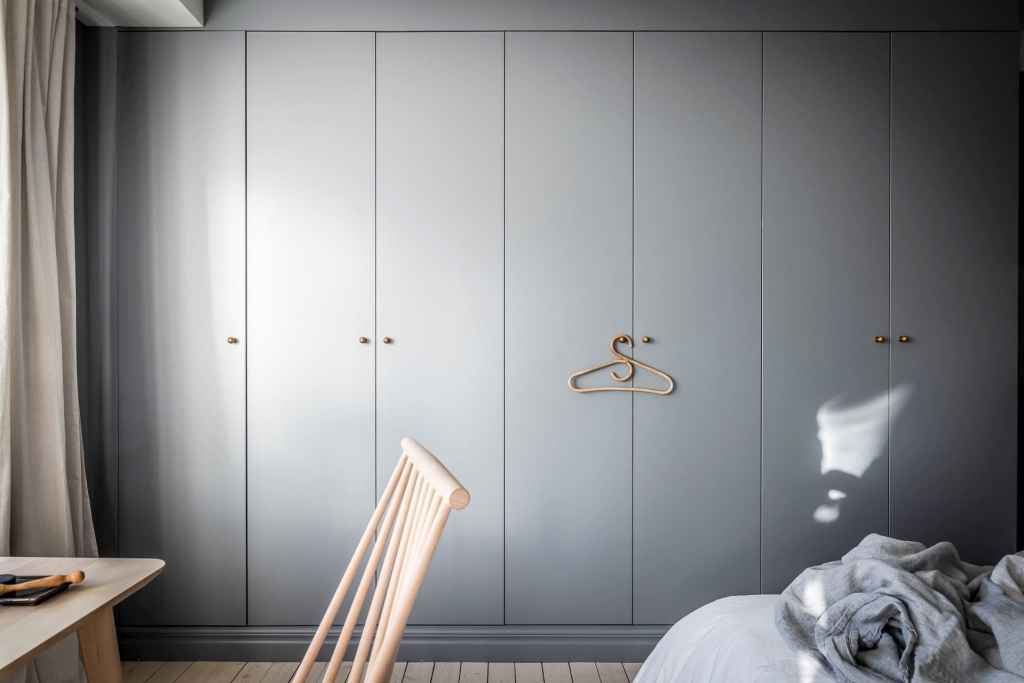 A simple and minimal grey wardrobe spreading across the entire bedroom wall