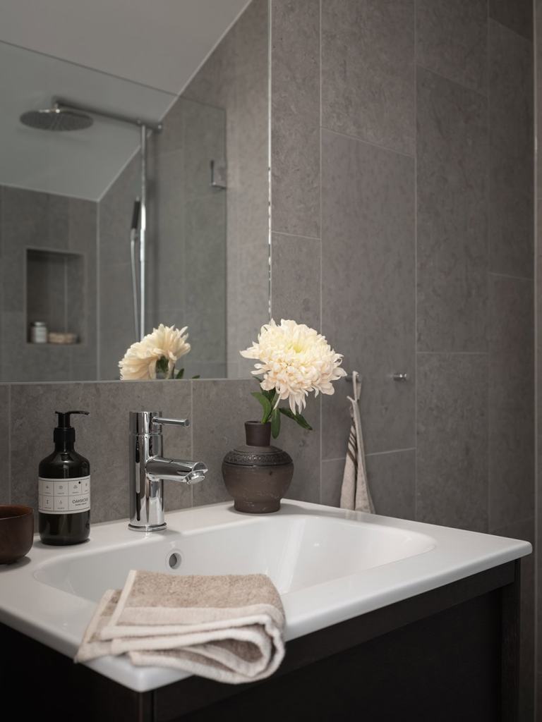 Limestone tiles paired with chrome bathroom fixtures