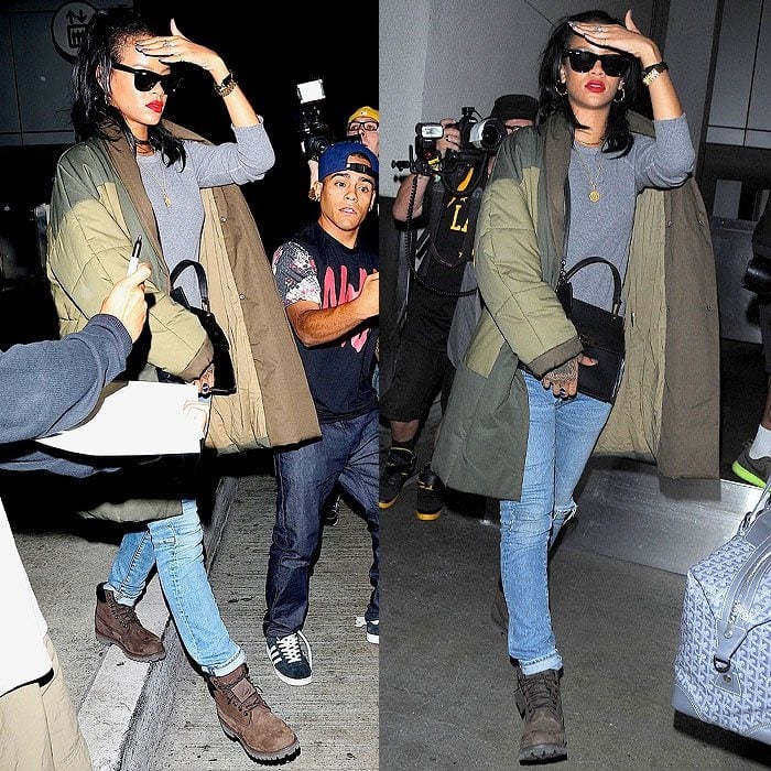 Rihanna layers up for a stylish winter look with Timberland boots, distressed skinny jeans, a gray top, and an oversized puffer coat, topped off with bold red lips